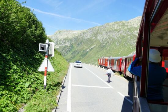 Die Furkastraße wird gekreuzt - die Schaffnerin hält den Verkehr an.