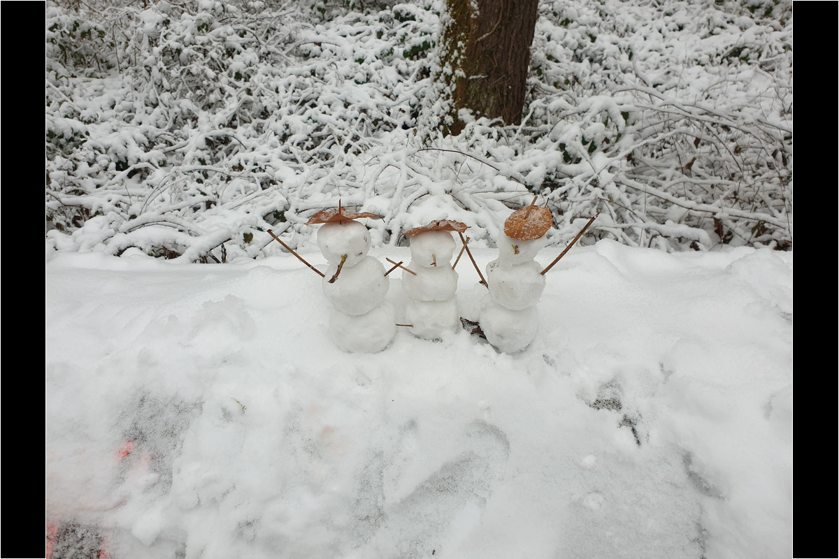 Da stehen drei kleine Gestalten am Wegrand.